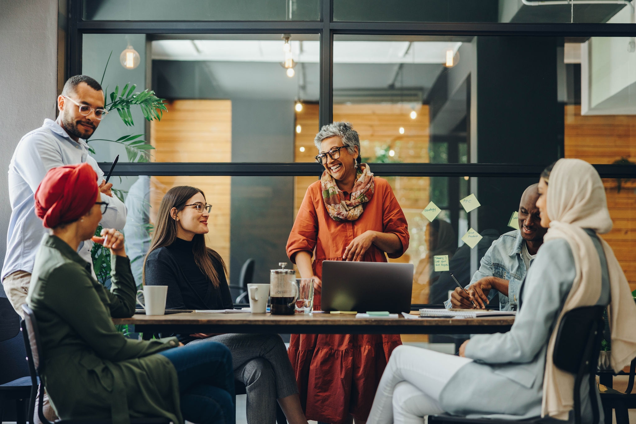 Cheerful businesspeople smiling happily during a meeting in a creative office. Group of successful business professionals working as a team in a multicultural workplace.