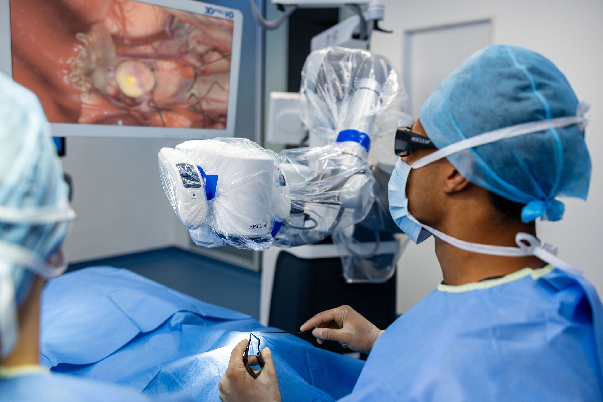 A surgeon performs a surgery with the Aesculap Aeos® while standing tall and looking at the monitor. 